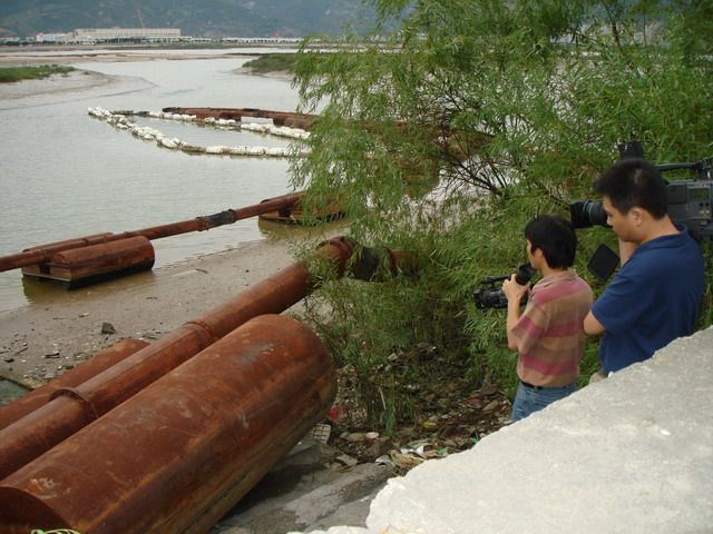 记者在拍摄湿地上还没有拆掉的确巨大吸沙管.jpg
